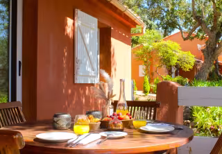 Table dressée pour le petit-déjeuner sur la terrasse d'une mini-villa