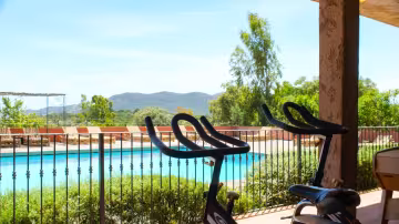 Vélos d'appartement face à la piscine et aux montagnes